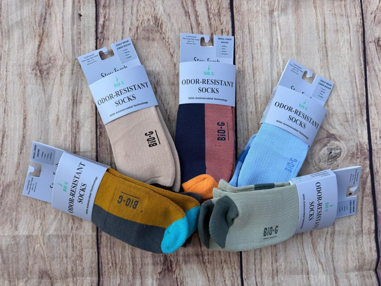 Five packs of BiO-G odor-resistant socks fanned out on weathered wood