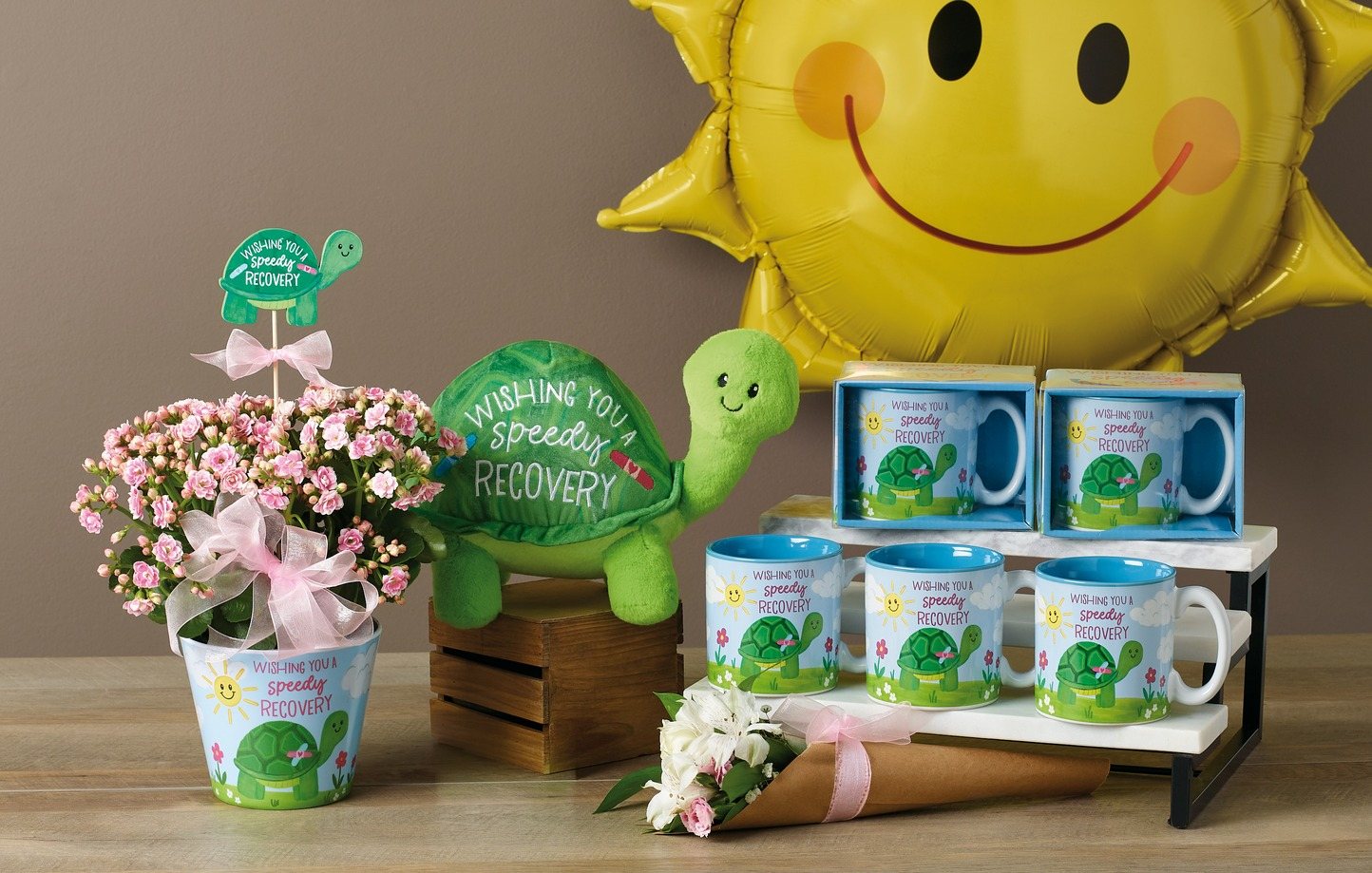 burton + BURTON Wishing You a Speedy Recovery gifts: a smiling sun balloon, mugs and a turtle plush